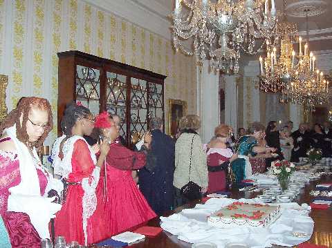 Everyone watches and prepares for Mr. Lincoln to cut the cake.